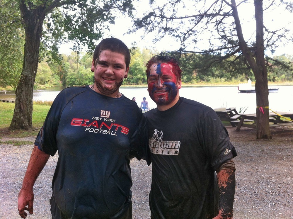 Two dirty runners posing after mud run