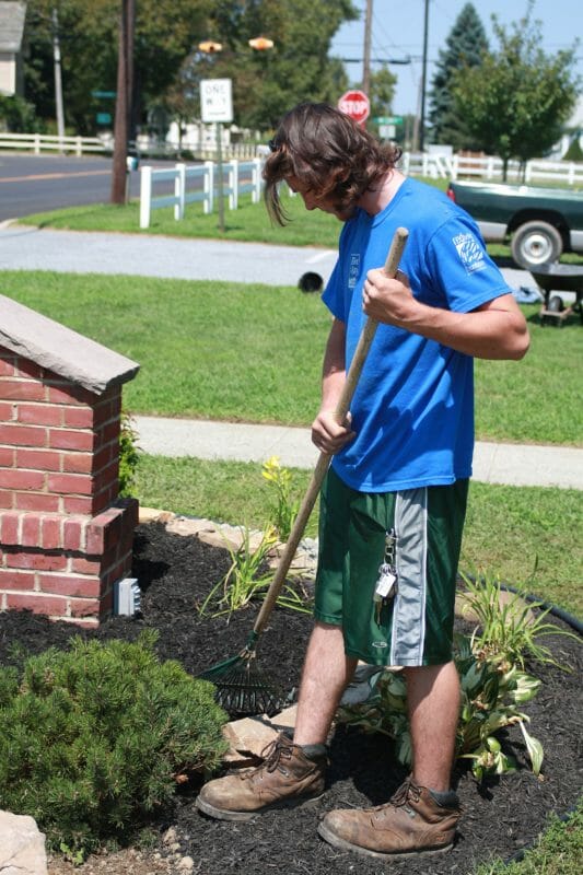 Young man working in flower plot
